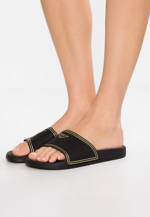 Zwarte slideslippers met een brede band, voorzien van gouden accenten en een gestructureerde zool. Open teen ontwerp met een gladde, matte afwerking.