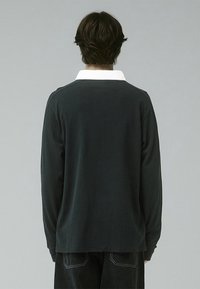 Long-sleeve shirt in dark gray with a white collar. Soft fabric, relaxed fit, and back seam detail. Casual style suitable for layering.