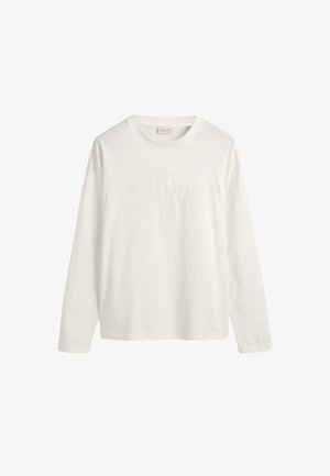 Fehér hosszú ujjú pamut póló, amelynek elején dombornyomott logó dizájn található, klasszikus kerek nyakkal. Puha tapintású, laza fazonú.