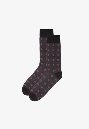 Chaussettes gris foncé avec un motif à pois marron. Elles présentent une bordure et un design de bout noirs solides ; fabriquées en tissu lisse avec une légère élasticité.