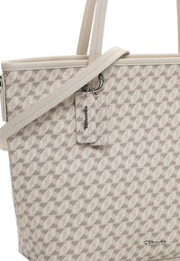 Sac fourre-tout beige avec un motif géométrique, fabriqué en tissu texturé. Il dispose de poignées doubles, d'une bandoulière amovible et d'une étiquette de marque.