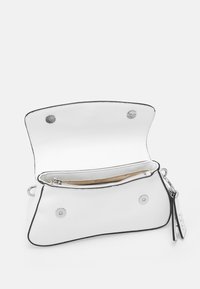 Witte handtas met een gestructureerde buitenkant, zwarte afwerking en zilveren hardware. De open flap onthult een beige interieur met een ritsvak.