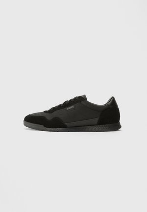 Zwarte lage sneaker met vetersluiting, gestructureerde zool, suède en stoffen panelen en klein "BOSS" logo aan de zijkant.