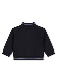 Veste à col et poignets côtelés de couleur bleu marine. Présente une accent rayé en bas. Fabriquée dans un tissu lisse et doux.