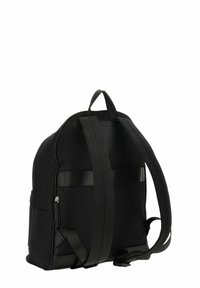 Sac à dos noir avec une texture lisse, une forme incurvée, des bretelles réglables, une poche zippée à l'avant et une poignée plate sur le dessus pour un transport facile.