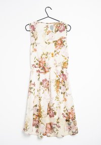 Blommig klänning på en galge, med en krämfärgad bas, korta ärmar och en rynkad midja, prydd med färgglada blommönster.