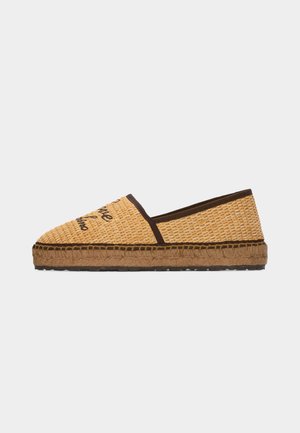 Zapato tipo espadrille sin cordones con parte superior de fibra natural tejida, ribete marrón, bordado de texto y suela gruesa de cuerda con suela exterior de goma negra.