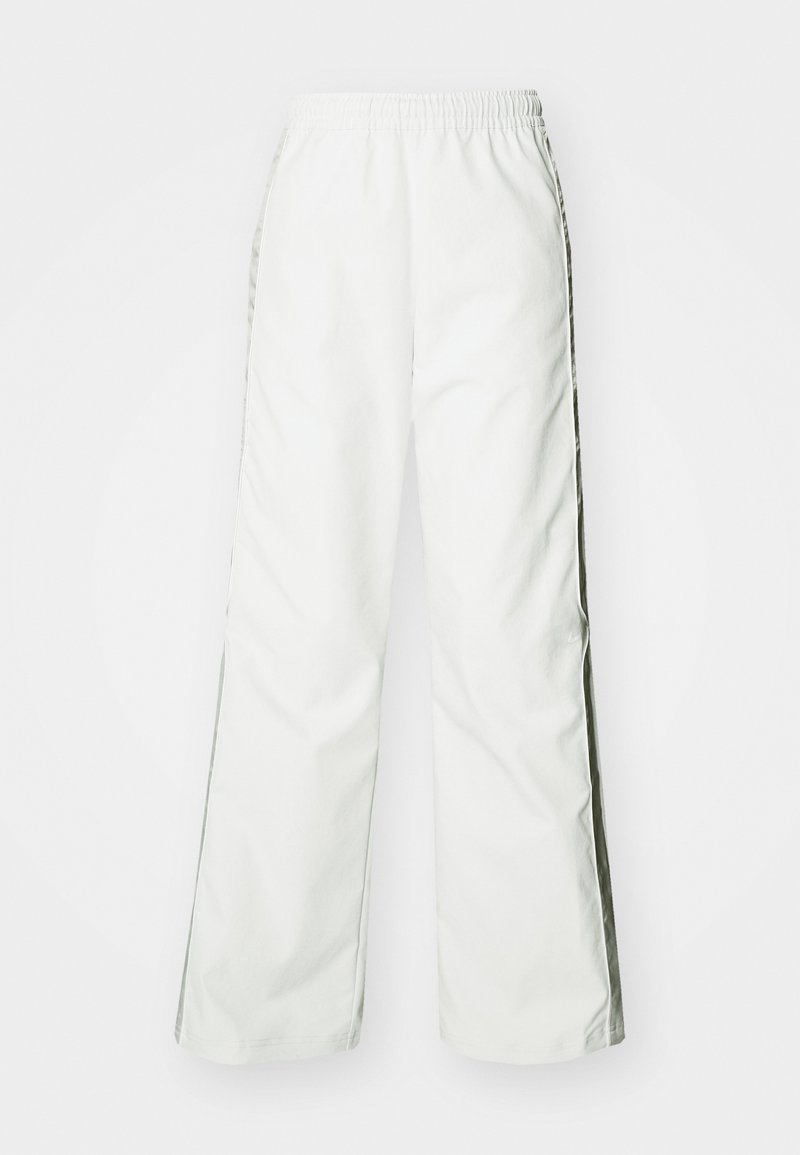 Weiße, weite Hosen mit elastischem Bund und kontrastierenden Seitenstreifen. Glatte Textur, minimalistisches Design, geeignet für die Freizeit.