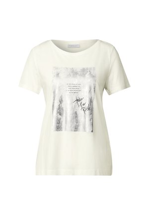 Valkoinen puuvillapaita lyhyillä hihoilla, jossa on hopeinen graafinen printti, jossa on teksti suorakulmaisessa muotoilussa ja käsinkirjoitettu lisäys, joka lukee "ota riski".