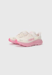 Chaussures de sport légères en blanc et rose. Dotées d'une tige en mesh respirant, d'un système de laçage sécurisé et d'une semelle rose rembourrée.