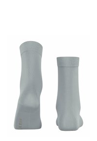 Light grey socks with a smooth texture and ribbed cuffs, featuring minimal design and subtle branding on the sole.