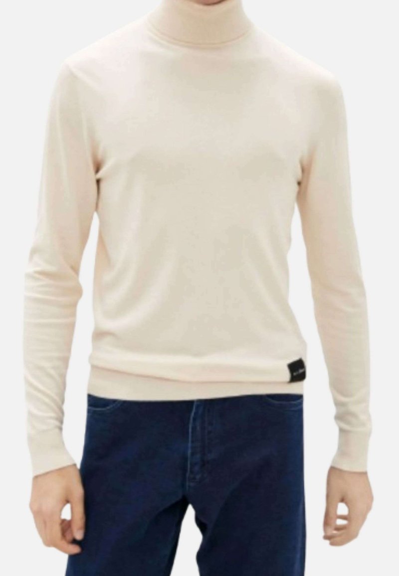 Pullover a collo alto beige chiaro realizzato in tessuto morbido; maniche lunghe aderenti e orlo a coste; etichetta visibile sul lato sinistro in basso.