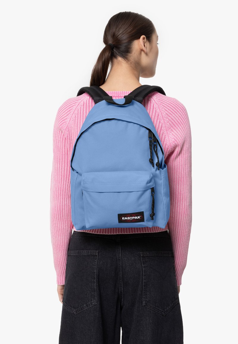 Ljusblå ryggsäck med en framficka med dragkedja, justerbara axelremmar och svarta detaljer. Tillverkad av hållbart tyg, idealisk för dagligt bruk.