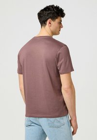 Brun kortärmad t-shirt med rund halsringning, tillverkad av mjukt bomullstyg, med en slät textur och en avslappnad passform.