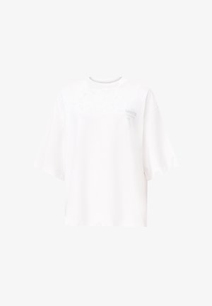 Camiseta blanca oversize hecha de algodón suave, con escote redondo y mangas cortas. Detalle sutil del logo en el frente.