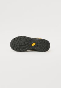 Sort gummisko sål med et klart træk mønster, der har et gult Merrell logo mærkat og spraglet detaljer overalt.