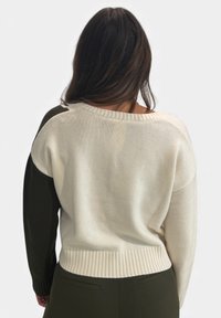 Maglione lavorato a maglia con sezioni crema e verde scuro, caratterizzato da un ampio scollo, orlo a costine e vestibilità morbida. Tessuto strutturato, stile informale e rilassato.