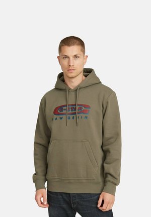 Olijfgroene hoodie van zacht materiaal, met een voorste kangoeroezak en een capuchon met trekkoord. Grafisch logo in blauw en rood op de borst.