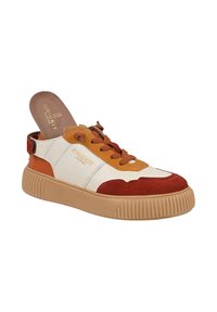 Sneaker o konstrukcji z różnych materiałów w kolorze kremowym, brązowym i rdzawym. Posiada masywną beżową podeszwę oraz sznurowane zapięcie z markową wkładką.