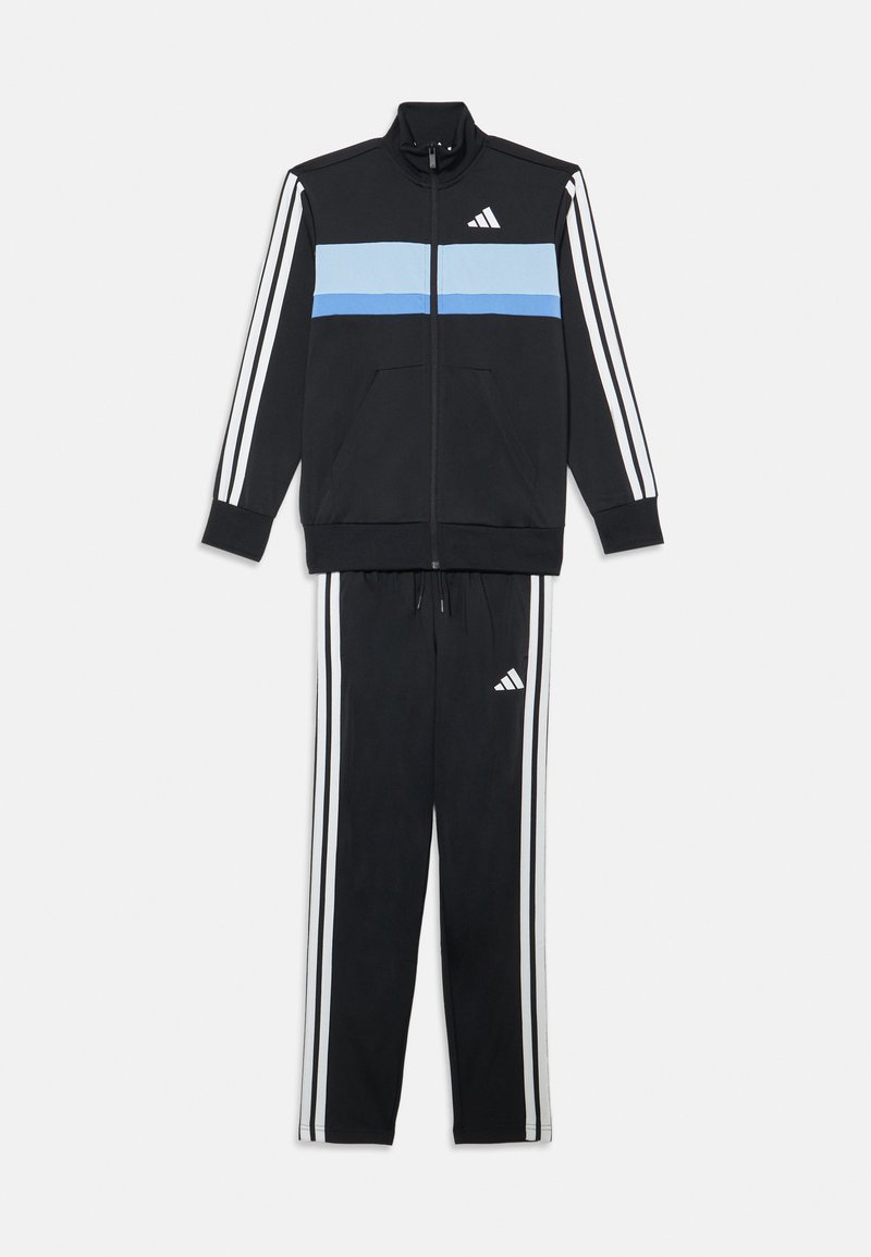Črn trenirko z zip vijakom, ki ima modre in bele črte, ter ujemajoče se hlače z belimi črtnimi detajli in logotipom Adidas.