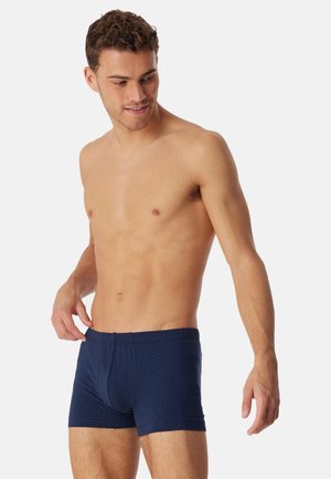 Boxer blu navy con motivo a pois testurizzato, dotati di fascia elastica in vita e design aderente.