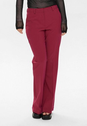Burgundy tailored trousers with a straight cut, belt loops, and a smooth, textured fabric, paired with black platform shoes.
