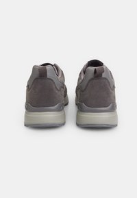Grey athletic shoes with a combination of smooth and textured materials, featuring a chunky sole and a pull tab on the heel.