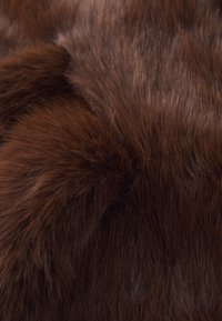 Brown faux fur fabric with long, soft hair fibers; dense texture with varying shades of rich brown and subtle highlights.