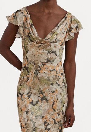 Gros plan d'une personne à la peau foncée portant une robe fleurie avec des manches courtes froncées délicates et un col drapé aux tons beige, vert et pêche.