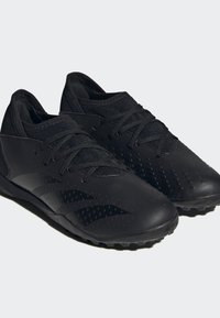 Zapatillas deportivas negras con parte superior sintética, exterior texturizado, lengüeta de malla transpirable y suela de goma con agarre para tracción.