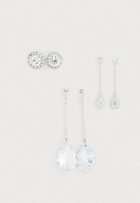 Quatre paires de boucles d'oreilles : deux paires de clous d'oreilles circulaires avec des strass clairs, et deux paires de boucles d'oreilles pendantes avec des cristaux en forme de poire en métal argenté.