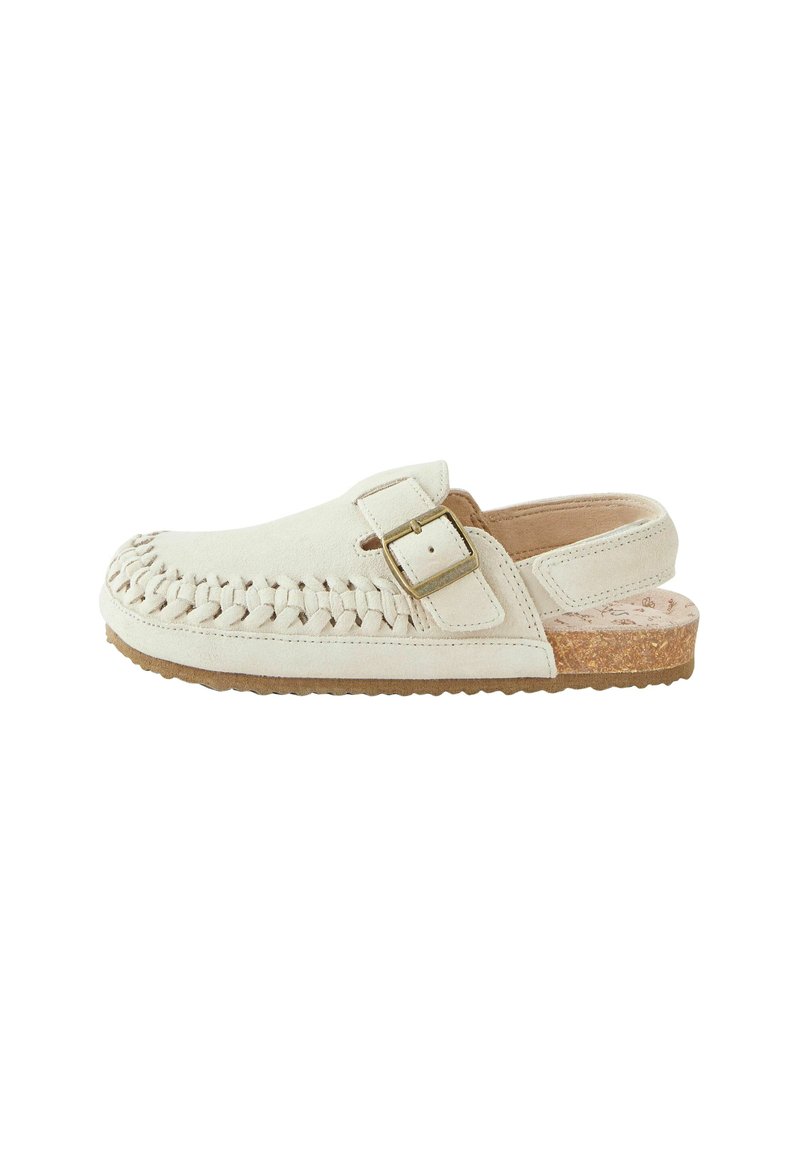 Sabot en daim blanc avec des détails en tresse à l'avant, une boucle dorée en accent, et une semelle en liège beige texturé.