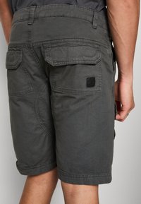 Cargo shorts in dark gray fabric, featuring multiple pockets, subtle stitching details, and a small black label near the waistband.