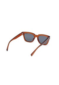 Ochelari de soare din plastic maro, cu formă cat-eye, lentile gri închis și brațe subțiri cu o mică curbură. Detalii hardware minime vizibile.