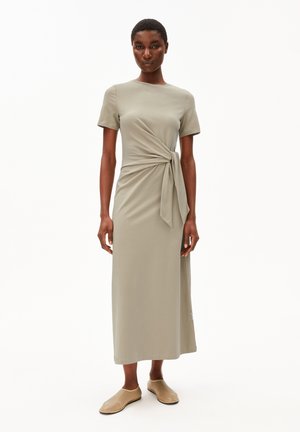 Knielanges, kurzärmeliges Kleid aus sanftem olivgrünem Stoff mit einem Frontknotendetail. Glatte Textur mit geradem Schnitt. Leicht.