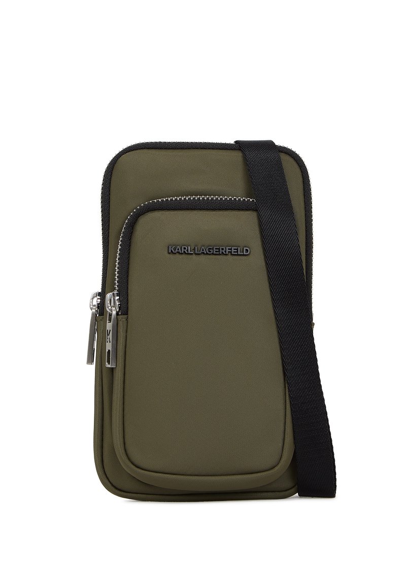 Borsa a tracolla in nylon verde oliva con tasca anteriore con zip, hardware argento e spallacci neri regolabili; presenta un dettaglio con logo sulla parte anteriore.