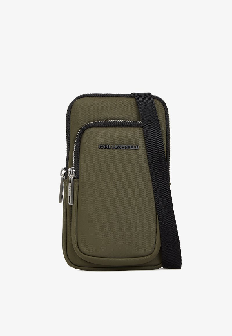 Maslinasto zeleni najlon torbica za preko tijela s prednjim zip džepom, srebrnim detaljima i crnim podesivim remenom; sadrži logo detalj na prednjoj strani.