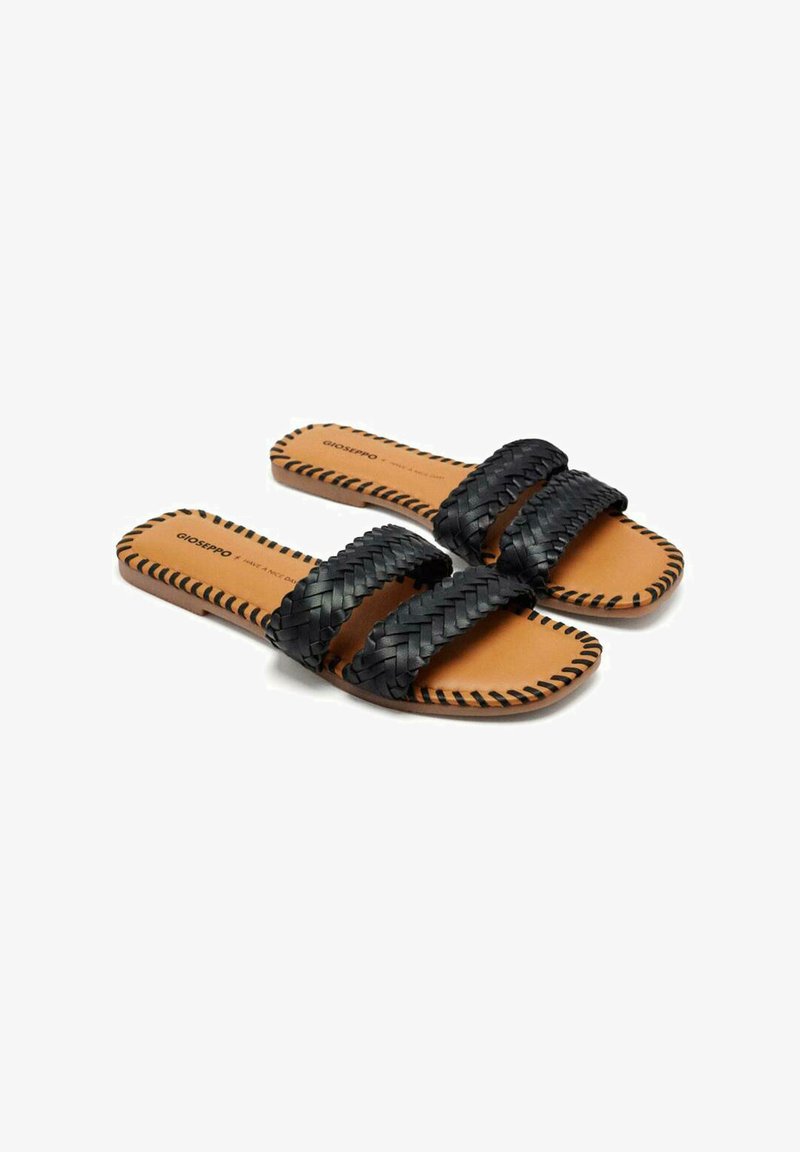 Sandalias de cuero trenzado negro con dos correas anchas y una plantilla color marrón. La suela presenta un tipo de costura decorativa. Diseño plano para mayor comodidad.