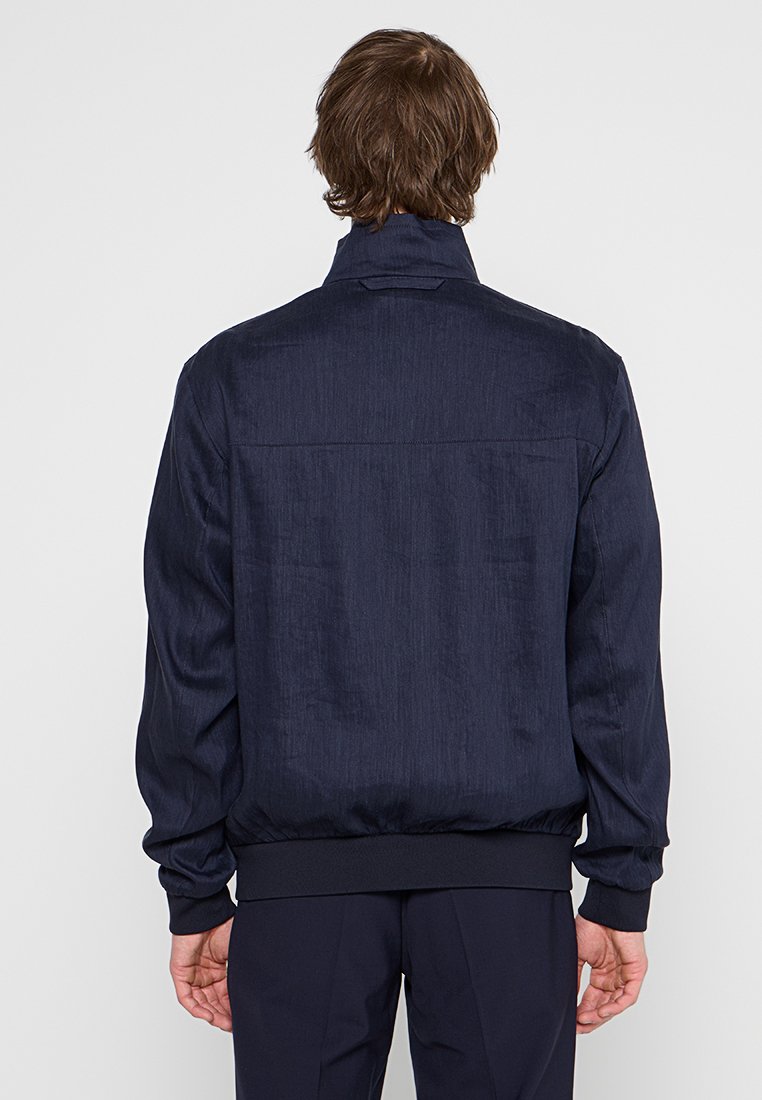 Marineblauer Bomberjacke aus strukturiertem Material, featuring einen hohen Kragen, elastische Bündchen und einen elastischen Saum. Schlichtes Design ohne Verzierungen.
