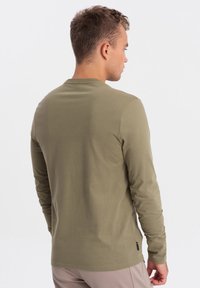 Olivgrünes Langarmshirt aus weicher Baumwolle, mit Rundhalsausschnitt und schmalem Schnitt, mit einfarbigem Design und minimaler Markenkennzeichnung.
