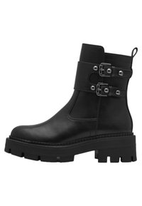 Bota de cuero negro hasta el tobillo con una suela gruesa, que cuenta con dos hebillas de correa ajustables y una pestaña de tiro en la parte trasera.