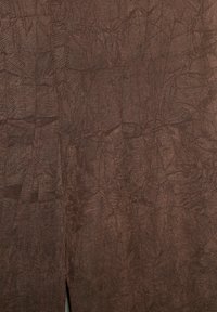 Tessuto marrone con trama e pieghe sottili, con una fessura verticale vicino al centro nella parte inferiore.