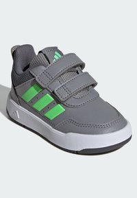 Szary but sportowy z zielonymi akcentami; posiada trzy paski na rzepy, teksturowany siateczkowy język oraz białą gumową podeszwę z czarnym bieżnikiem.