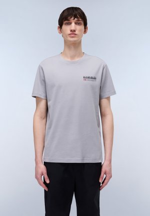 Hellgraues Baumwoll-T-Shirt mit kurzen Ärmeln, Rundhalsausschnitt und kleinem Logo auf der linken Brust. Glatte Textur, lässige Passform.
