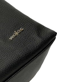 Borsa nera in pelle texturizzata dalla forma rettangolare, con dettagli in metallo dorato. La superficie ha una finitura granulosa per una maggiore durata.
