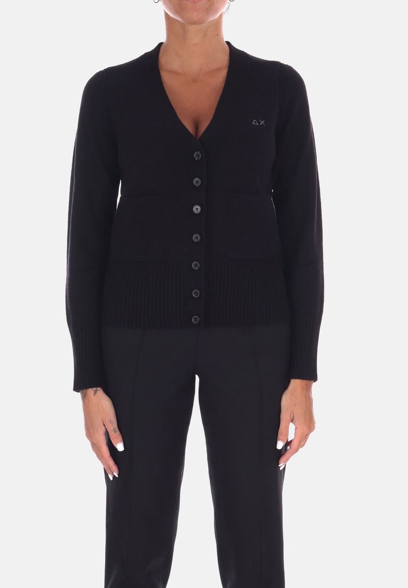 Cardigan nero con scollo a V, chiusura a bottoni, due tasche frontali e orlo a costine. Realizzato in tessuto morbido con una texture liscia.