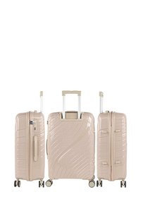 Tres maletas rígidas beige con patrón de ondas, cremalleras metálicas, asas retráctiles altas y cuatro ruedas para facilitar la movilidad.