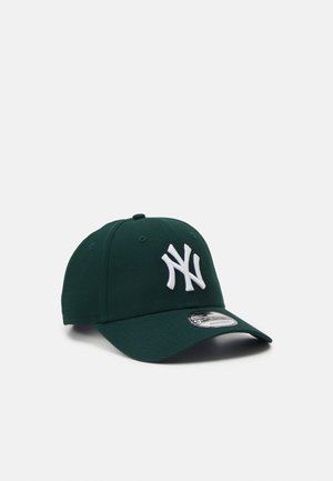 Tummanvihreä lippalakki, jossa valkoinen kietoutunut "NY"-logo edessä ja käyrä lippa, jossa hopeinen tarra päällä.