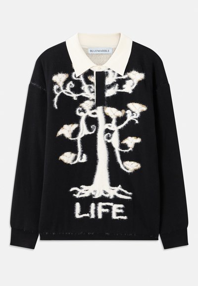 Juodas megztinis su balta medžio rašyba ir žodžiu "GYVENIMAS" apatinėje dalyje. Yra kreminės spalvos apykaklė ir švelni, tekstūruota medžiaga.