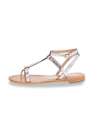 Sandali piatti metallici argento con design a T-strap, punta aperta e fibbia alla caviglia regolabile. Suola in simil legno naturale. Texture liscia.